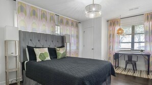 Une chambre avec un grand lit, un bureau et une chaise.