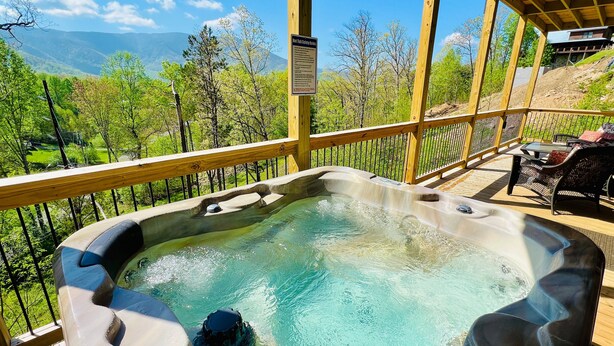 A hot tub with a wooden deck and a sign about safety rules. - A Tyme to Chill (Sevierville)