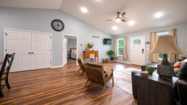 A spacious living area with hardwood flooring, a ceiling fan, and a seating area with a sofa and chairs. - Red River Gorge, Hollerwood Stays! High Speed Wi-Fi, Pet-Friendly! New Home! (Clay City)