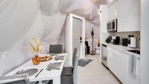 Eine Zelthotelunterkunft mit Essbereich und Küchenzeile.