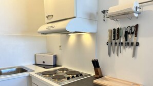 Una cocina moderna con estufa, tostadora y un soporte para cuchillos.