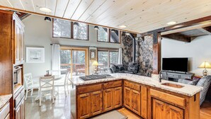 Una cocina amplia con armarios de madera, una isla grande y una chimenea de piedra.