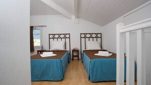 A room with two beds, wooden flooring, white walls, and a sloped ceiling. - Logement à 700m de la plage, sur le golf Moliets ! (Moliets)