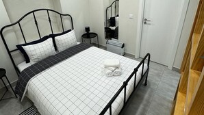 A neatly arranged bedroom with a bed, bedside tables, a mirror, and a wardrobe. - Refugio do Principe Real (Lisboa)