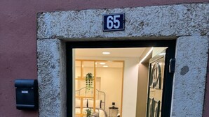 A doorway with a number "65" above it, leading into a room with a sofa, a small table, and a plant. - Refugio do Principe Real (Lisboa)