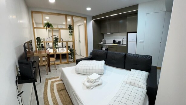 A compact bedroom with a bed, bedside tables, a desk, and a kitchenette. - Refugio do Principe Real (Lisboa)