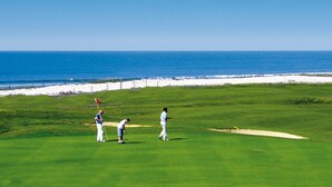 Ein Golfplatz mit Blick auf das Meer.