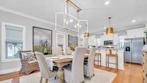 A modern kitchen with a central island, stainless steel appliances, and pendant lighting. - 🦩Book Me Baby! Ain't Life Grand 30A~GolfCart~6bikes🦩 (Santa Rosa Beach)