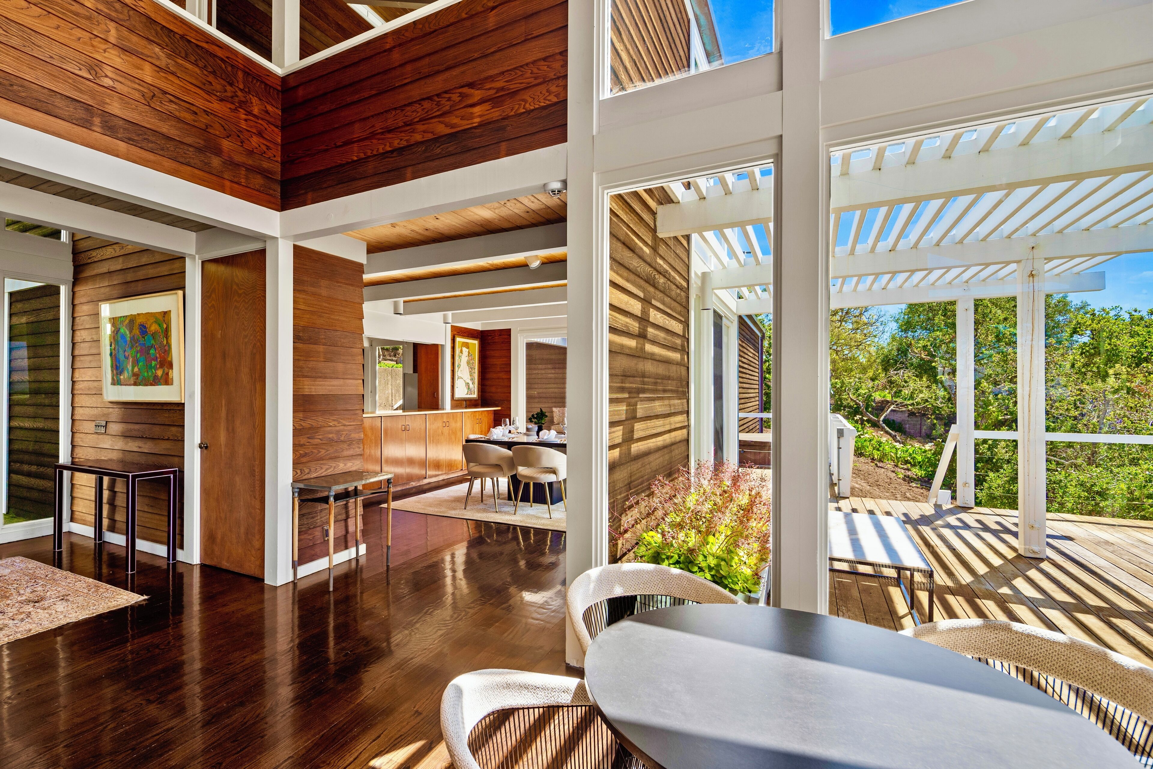 Un interior moderno con paneles de madera, un comedor y vistas al exterior.