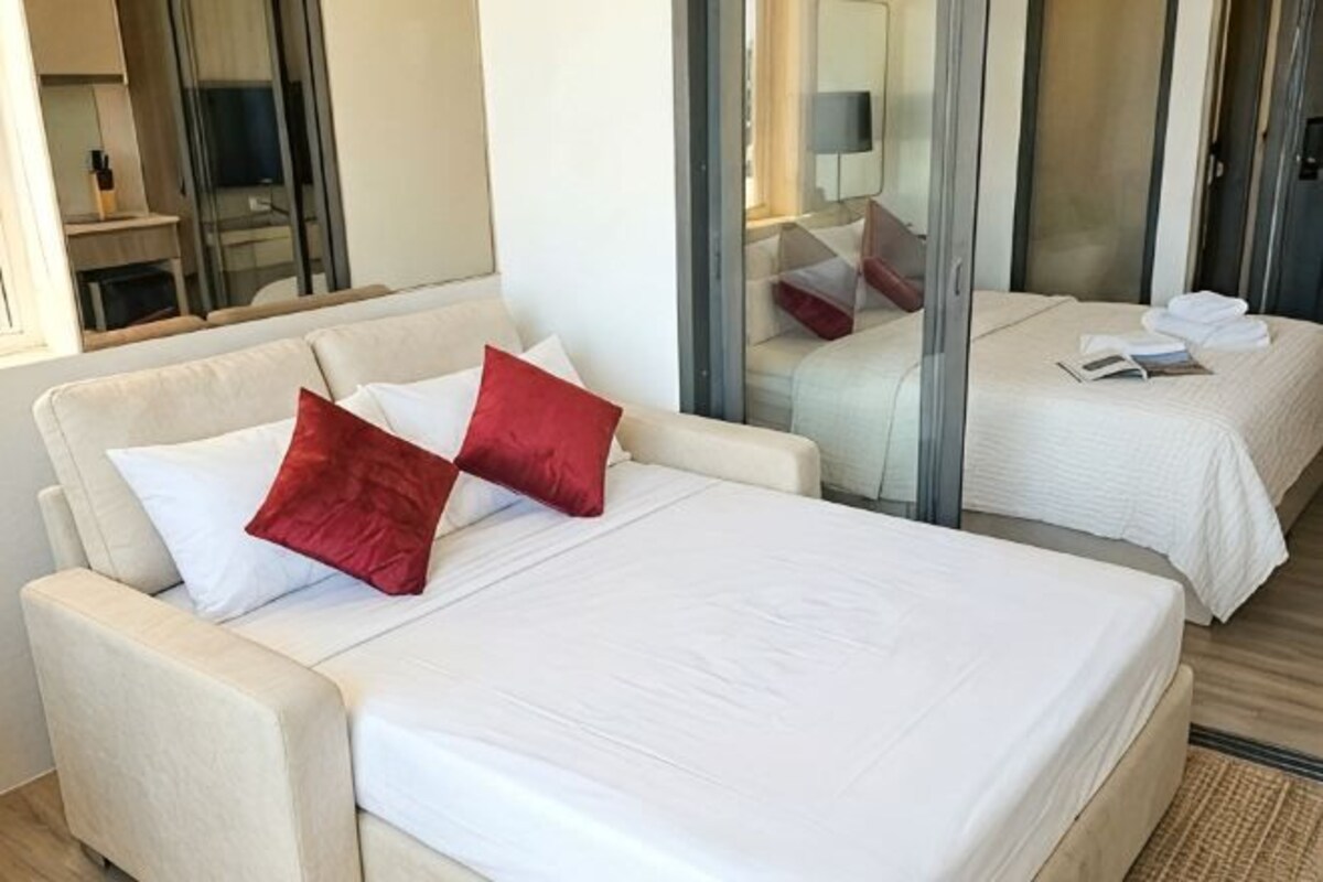 A hotel room with a bed, a sofa, and a small table.