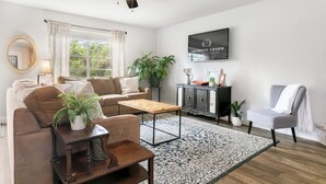Una sala de estar moderna con un sofá, una mesa de centro y un televisor montado en la pared.