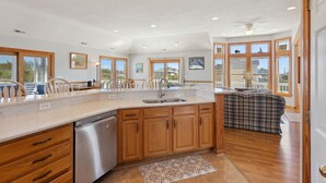 A spacious kitchen with wooden cabinets, a dishwasher, and a large island. - Despacito: Pool, Hot Tub, Walk to Beach OBX (Corolla)