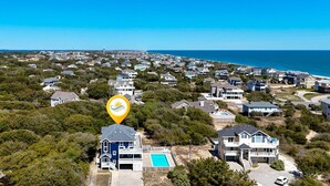 A coastal residential area with houses, a swimming pool, and a view of the ocean. - Despacito: Pool, Hot Tub, Walk to Beach OBX (Corolla)