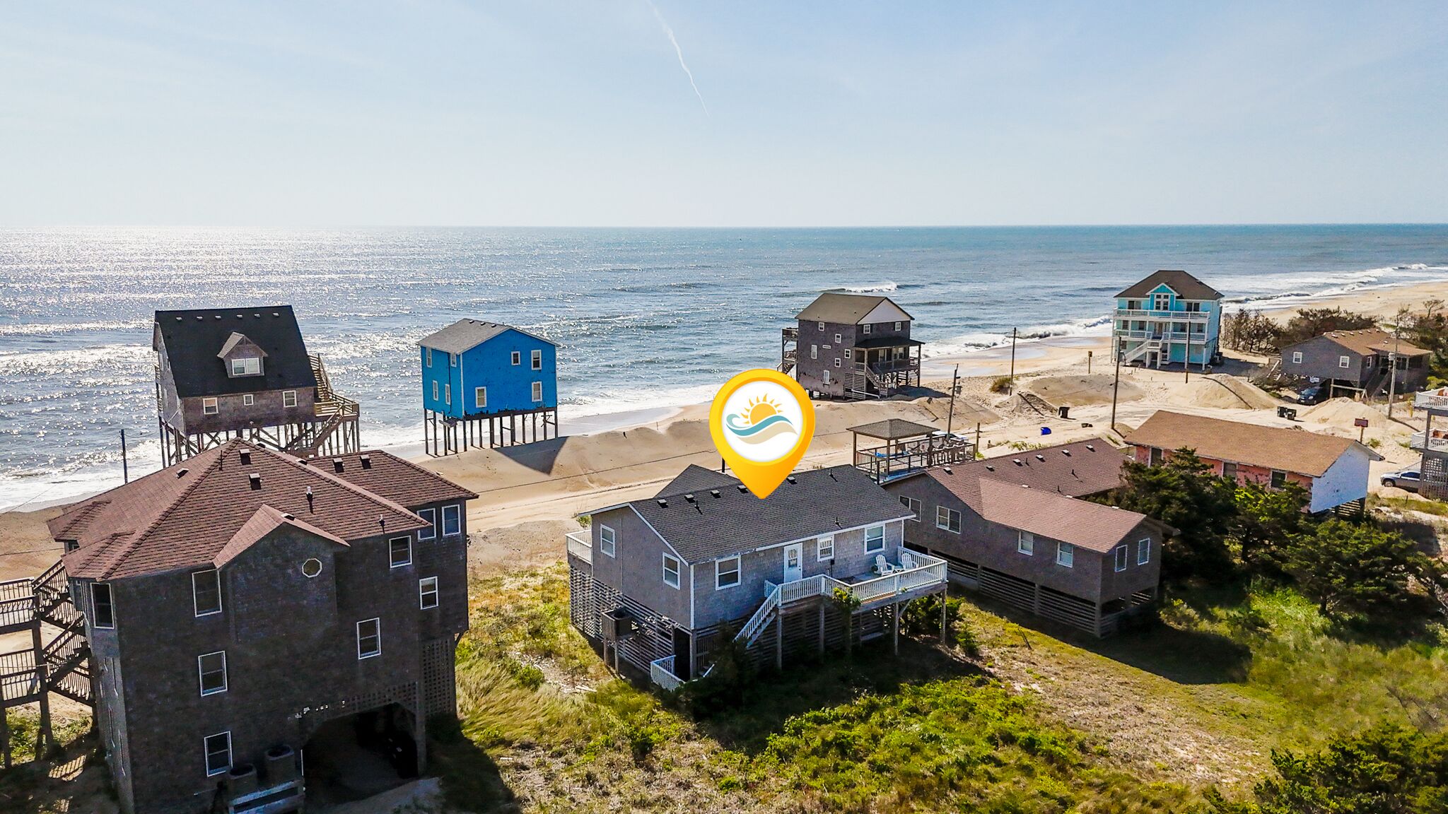 Una zona costera con edificios sobre pilotes, una playa y el océano.