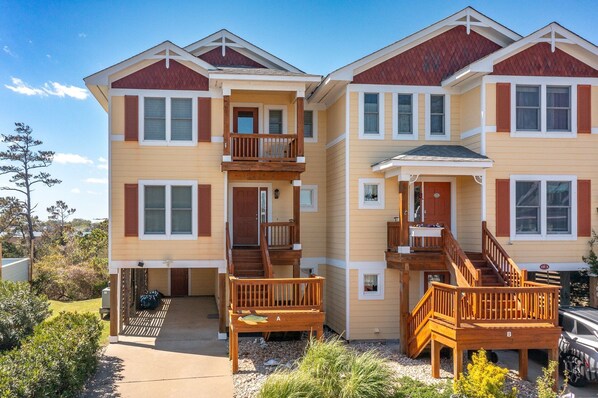 A two-story residential building with a balcony on the first floor and a covered porch on the second. - CP100A Sound Sunset * Stunning Sunsets over Water (Kill Devil Hills)