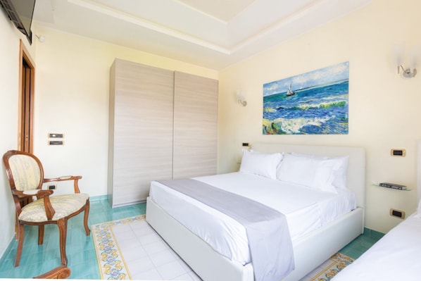 Un dormitorio con cama, una silla, un armario y un cuadro de un velero en la pared.