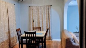 Un espace repas comprenant une table et des chaises, un canapé et une vue sur l’extérieur.