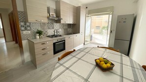 Une cuisine moderne équipée d’une cuisinière à gaz, d’un four et d’un coin repas avec une table mise pour deux personnes.