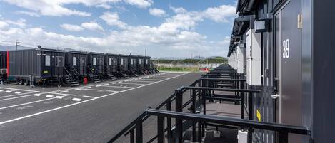 Uma área de estacionamento com fileiras de contêineres de transporte e um edifício com o número 39.