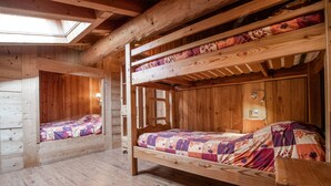 A wooden cabin with bunk beds, a skylight, and a wooden floor. - Apartment 'Les Mélèzes' with Mountain View, Balcony and Wi-Fi (SOLLIERES SARDIERES)