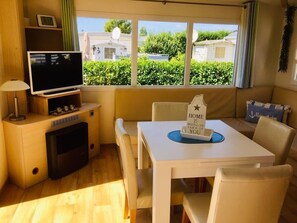 A compact living space with a TV, a small table, and a sofa. - Chalet 'Strandliebe Bredene' with Private Terrace (Bredene)