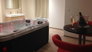 Un baño moderno con una bañera grande, un lavabo y un espejo.