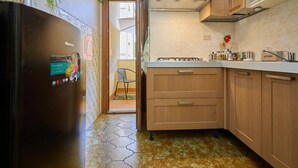 Una cocina con armarios de madera, estufa a gas y refrigerador.