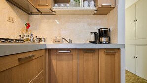 Una cocina con armarios de madera, una cafetera y un cartel que dice 'KITCHEN'.