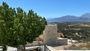 A stone building with a balcony overlooking a coastal landscape with mountains in the distance. - Apartment 'Spitiko  1' with Sea View, Shared Terrace and Wi-Fi (????????)
