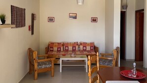 A living room with a sofa, chairs, a coffee table, and a dining table with chairs. - Apartment 'Spitiko  1' with Sea View, Shared Terrace and Wi-Fi (????????)