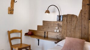 A wooden chair, a wooden bench, a bed with a pillow, a wall-mounted light fixture, and a wooden wall panel. - Apartment 'Nespolo' with Sea View, Wi-Fi and Air Conditioning (Finale Ligure)