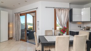 Un comedor con una mesa, sillas y vistas a través de un ventanal.