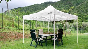 A tent with a table and chairs set up outdoors, surrounded by greenery and hills. - Villa 'Il Frutteto 50' with Private Terrace and Wi-Fi (Ortovero)
