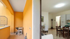 A hallway with a dining area, a staircase, and a kitchen. - Villa 'Il Frutteto 50' with Private Terrace and Wi-Fi (Ortovero)