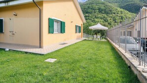 Un bâtiment doté d’un toit plat, d’une zone pavée et d’une pelouse.