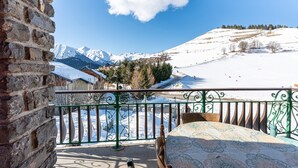 A balcony with a view of snow-covered mountains, a stone wall, and a metal railing. - Apartment 'Grand Balcon' with Mountain View and Balcony (Albiez-Montrond)