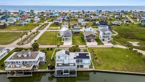 A coastal residential area with houses, a marina, and a view of the ocean.