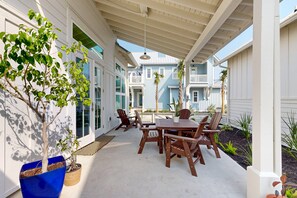 Enjoy dining or socializing in this serene outdoor patio area with a table and chairs, surrounded by lush greenery and a beautiful pergola.