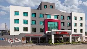 A multi-story hotel with a modern design, featuring a prominent red accent wall and a sign for 'Hotel Polomax'. - Max Hotel Jabalpur (Kolkata)