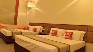 Habitación de hotel con dos camas, cada una con un almohadón que muestra el logo del hotel.