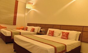 A hotel room with two beds, each with a pillow displaying the hotel's logo. - Max Hotel Jabalpur (Kolkata)