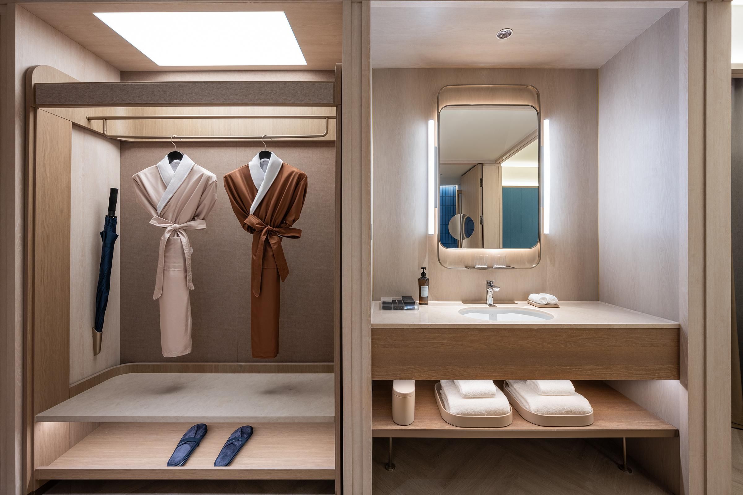 A modern bathroom with a vanity, mirror, and storage shelves.