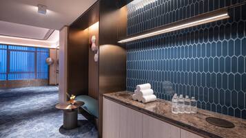 Un baño de hotel moderno con tocador, barra para toallas y pared con estampado azul.
