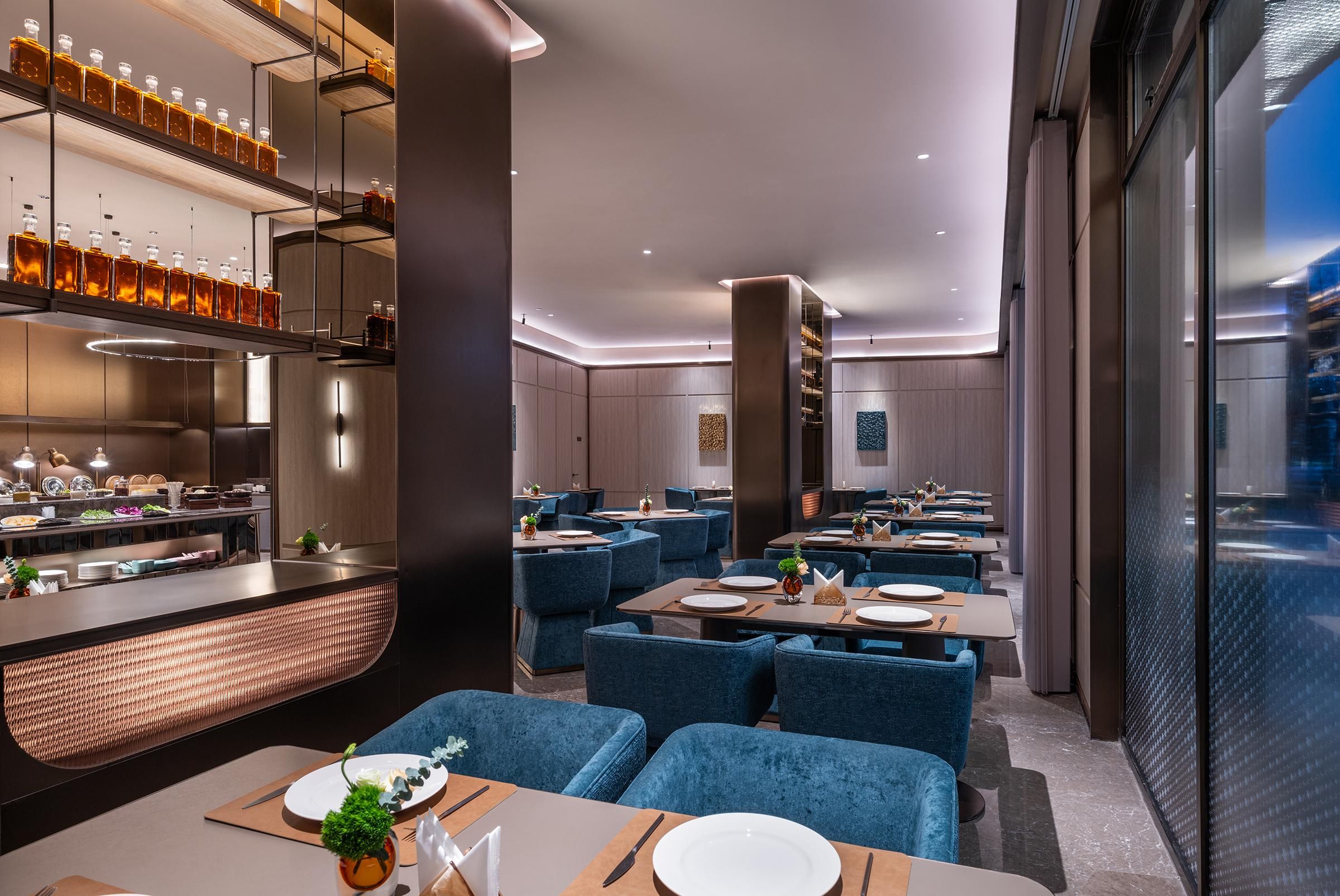 Un interior de restaurante moderno con zona de bar, asientos y vistas a través del muro de cristal.