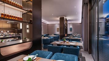Un interior de restaurante moderno con zona de bar, asientos y vistas a través del muro de cristal.