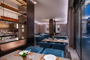 A modern restaurant interior with a bar area, seating, and a view through the glass wall. - Crystal Orange Hotel Nanjing Southeast University (Nanjing)