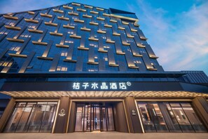 Een modern hotelgebouw met een opvallende gevel, gekenmerkt door een patroon van ramen en balkons.