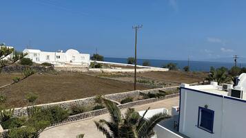 A coastal property with white buildings, a paved area, and a view of the sea.