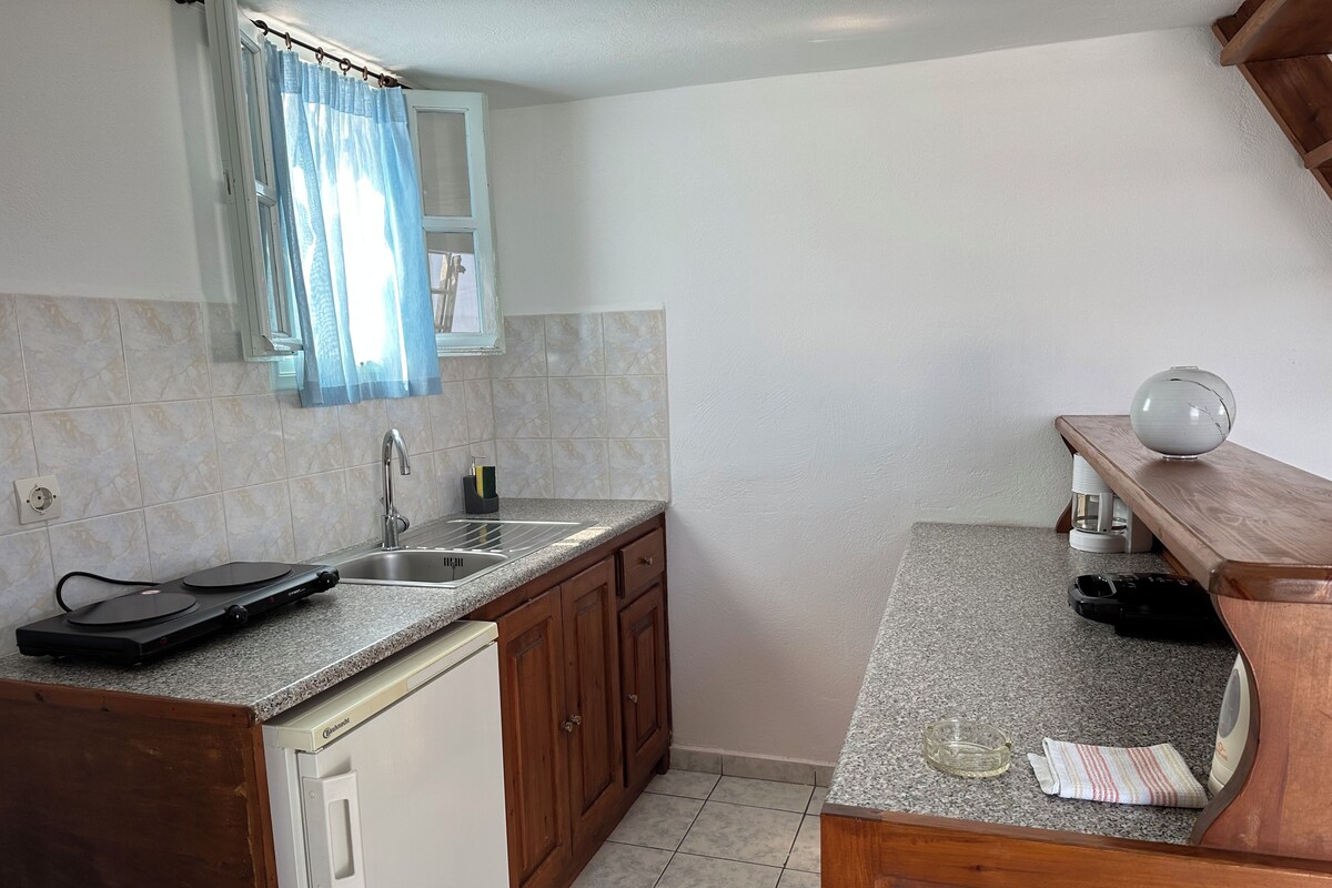 A kitchen with a sink, a dishwasher, and a wooden countertop.