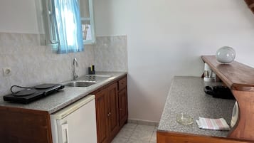 A kitchen with a sink, a dishwasher, and a wooden countertop.